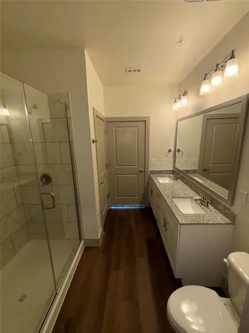 a bathroom with a granite countertop sink toilet and shower