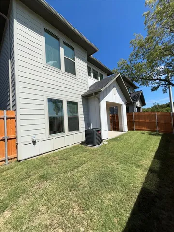 a view of a yard in front of a house with a large tree
