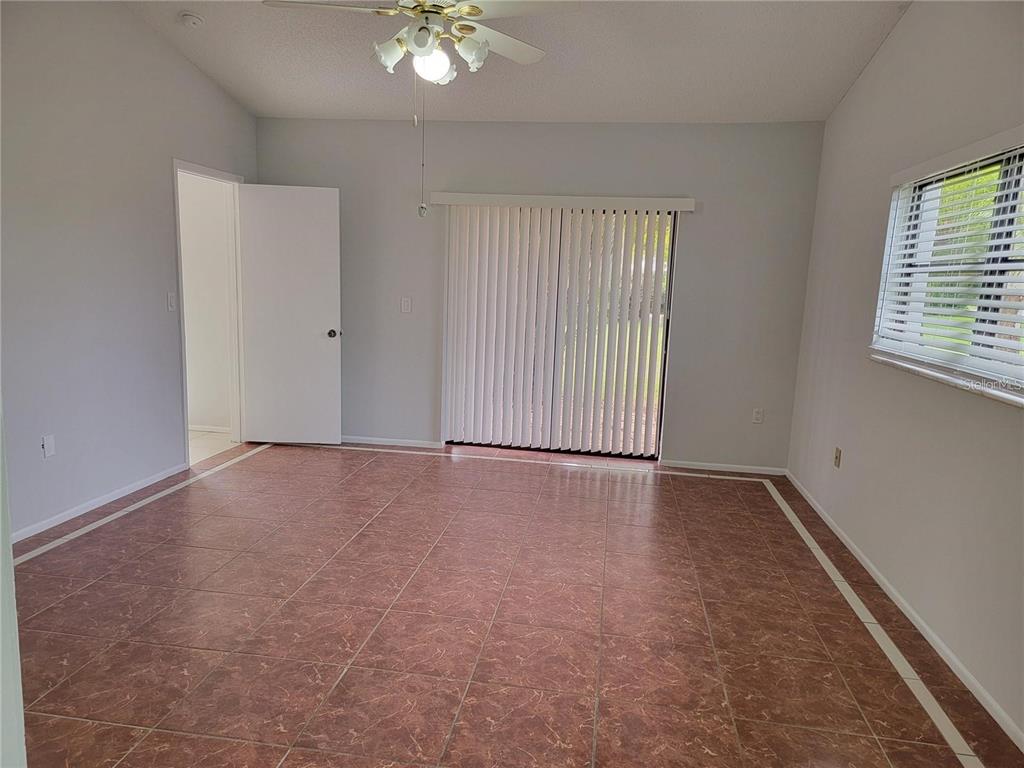 26221 Constantine Road Punta Gorda, FL 33983 - Photo 9 of 27 an empty room with windows and chandelier fan