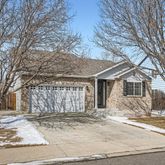 a front view of a house with a yard covered in snow