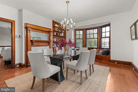 a kitchen with stainless steel appliances granite countertop a stove top oven a sink dishwasher a dining table and chairs with wooden floor