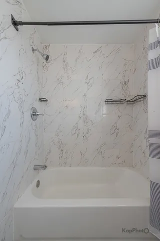 a bathroom with a shower and a bath tub