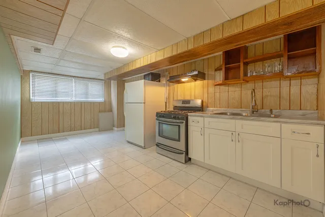 a kitchen with cabinets and chairs