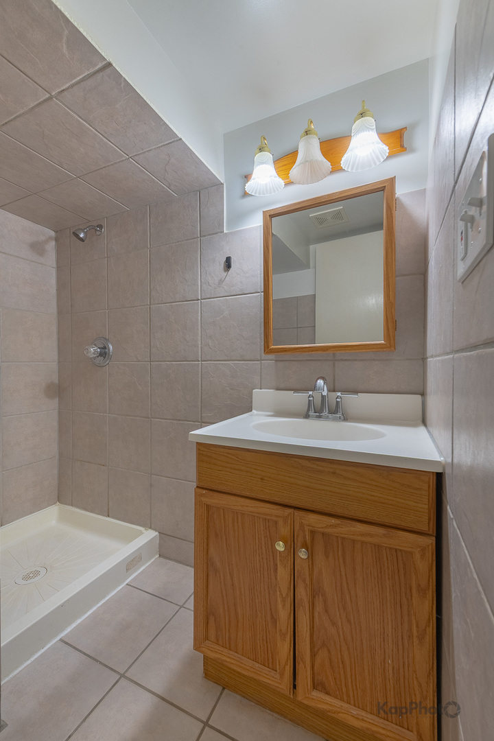 3704 West 57th Street Chicago, IL 60629 - Photo 27 of 30 a bathroom with a sink a vanity and mirror