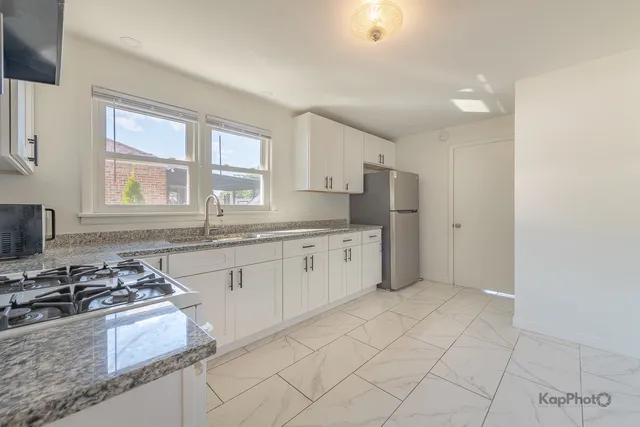 a kitchen with stainless steel appliances granite countertop a stove a sink and a refrigerator