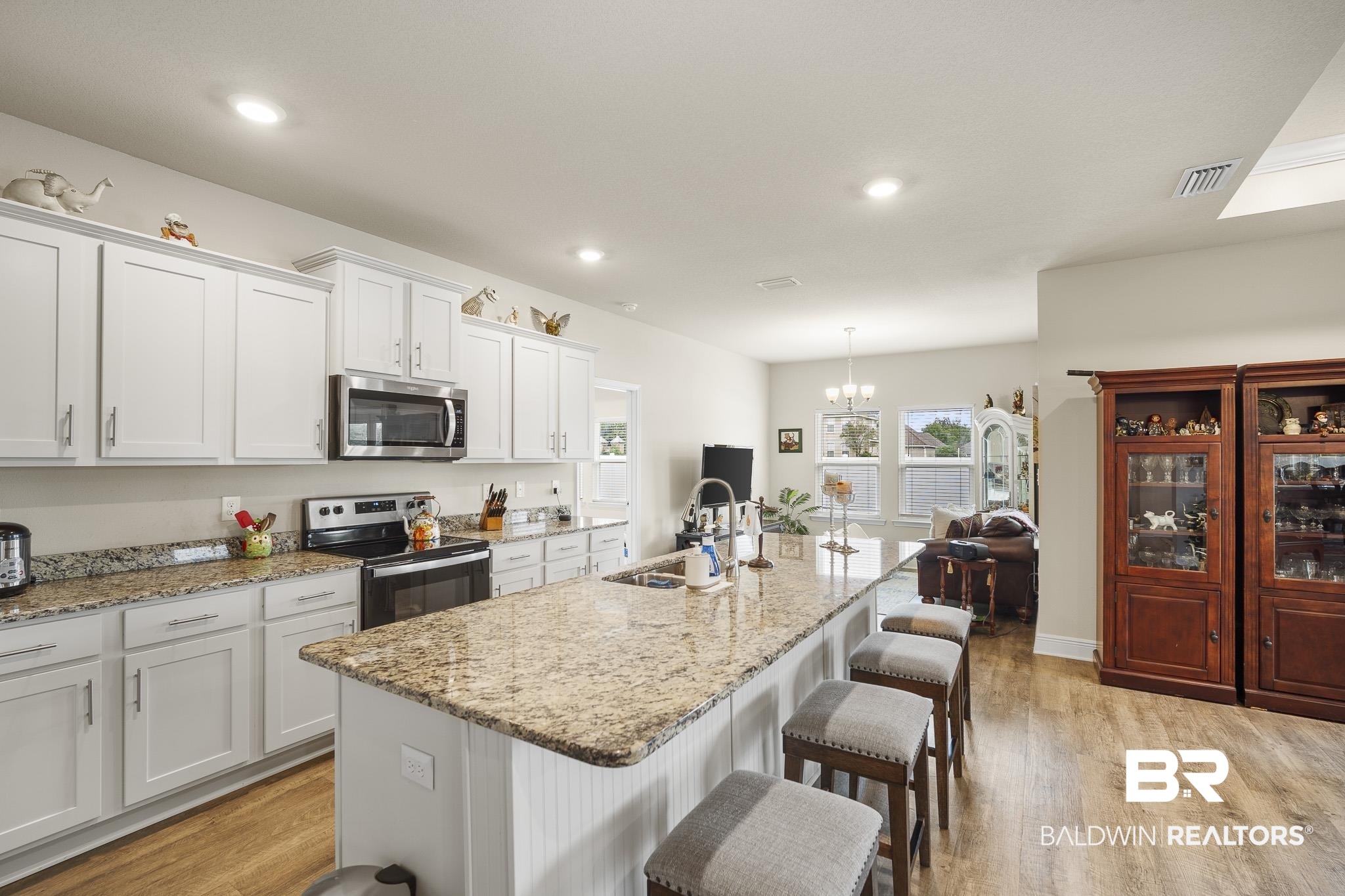 24765 Spectacular Bid Loop Daphne, AL 36526 - Photo 18 of 45 Kitchen featuring stainless steel appliances, a kitchen island with sink, sink, and white cabinets