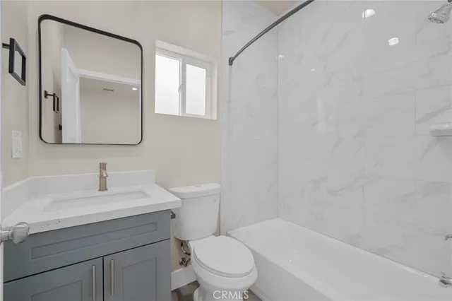 a bathroom with a toilet a sink a mirror and a bathtub