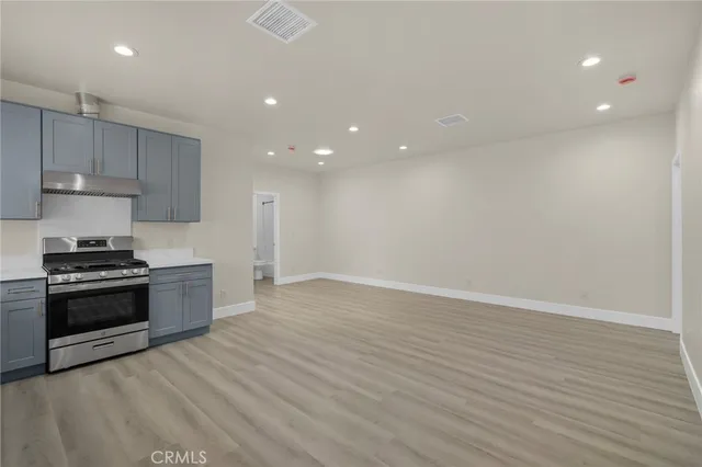 a large kitchen with stainless steel appliances granite countertop a stove a sink and a refrigerator