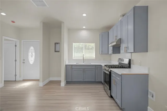 a kitchen with a sink stove and cabinets