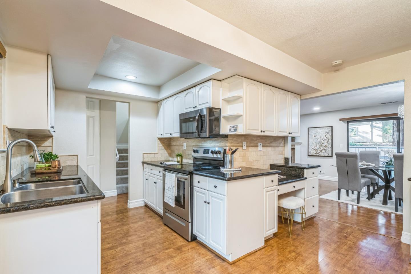 5348 Brookside Court Pleasanton, CA 94588 - Photo 17 of 30 a kitchen with stainless steel appliances granite countertop a stove top oven a sink a dining table and chairs