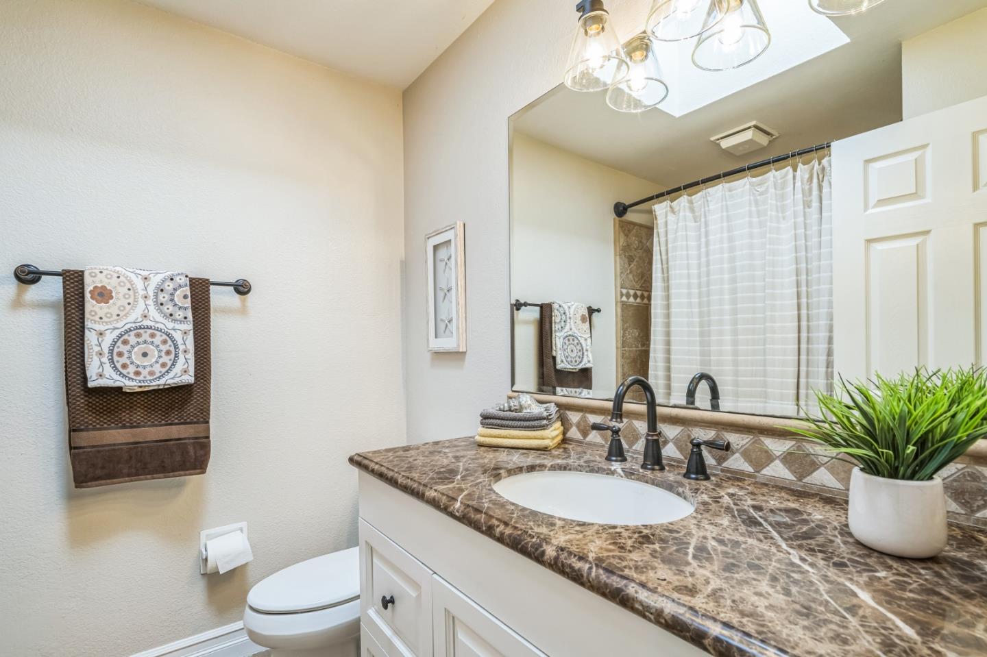 5348 Brookside Court Pleasanton, CA 94588 - Photo 23 of 30 a bathroom with a granite countertop sink a toilet and a mirror