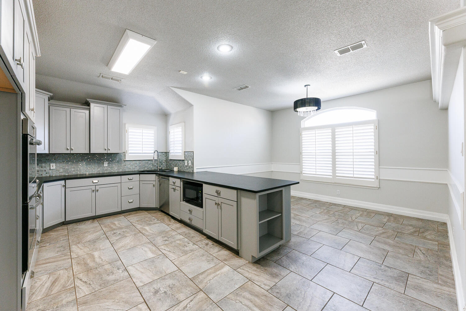 4503 108th Street Lubbock, TX 79424 - Photo 14 of 53 a kitchen with stainless steel appliances granite countertop a stove a sink and white cabinets