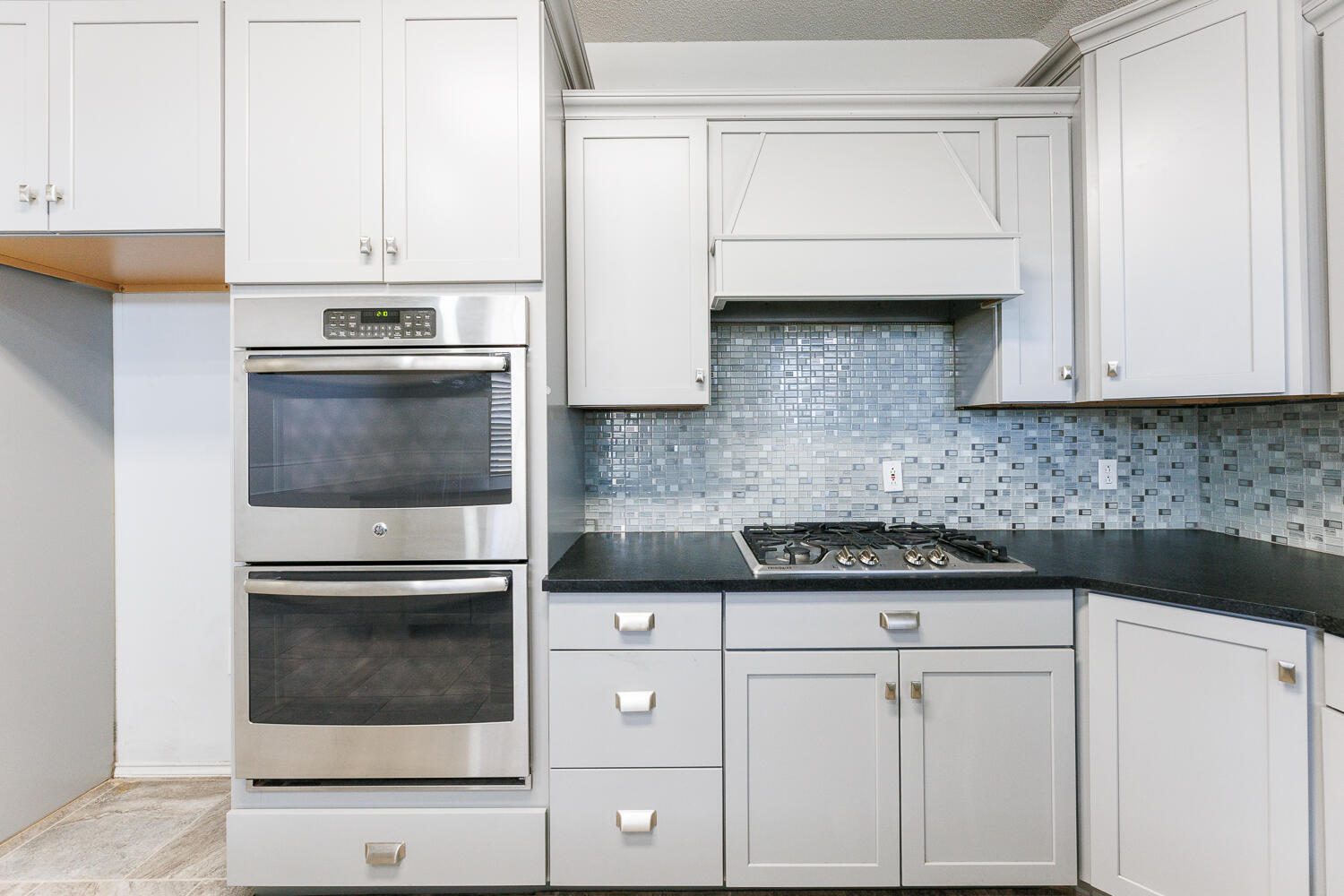 4503 108th Street Lubbock, TX 79424 - Photo 17 of 53 a kitchen with white cabinets and stainless steel appliances