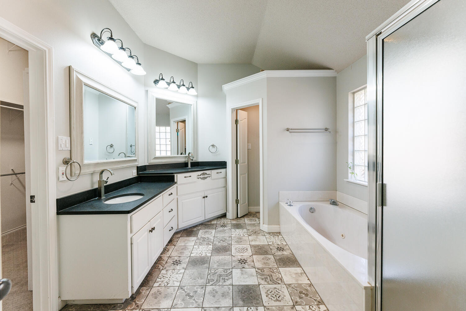 4503 108th Street Lubbock, TX 79424 - Photo 28 of 53 a large bathroom with a granite countertop tub double vanity sink and a mirror