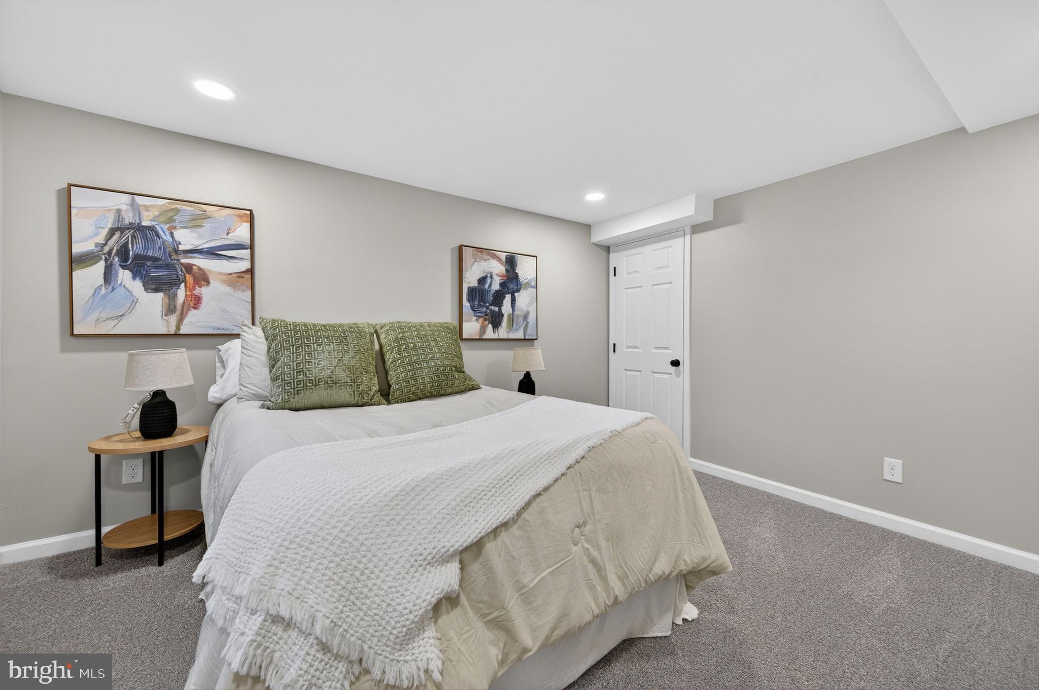 914 Dennis Avenue Silver Spring, MD 20901 - Photo 30 of 37 a spacious bedroom with a bed and a painting on the wall