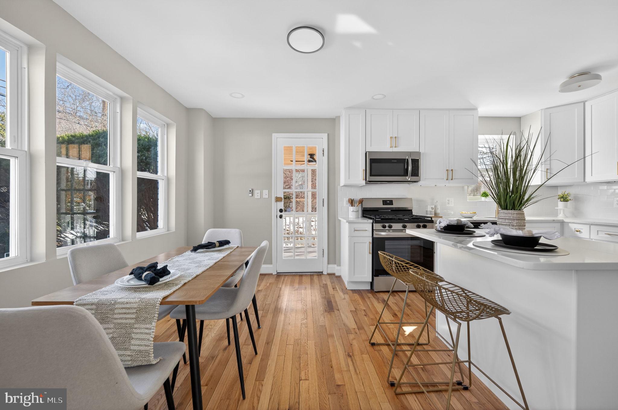 914 Dennis Avenue Silver Spring, MD 20901 - Photo 9 of 37 a kitchen with a table chairs refrigerator and microwave