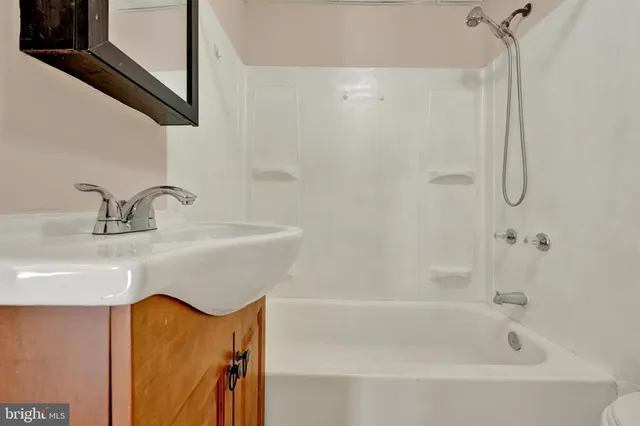 a bathroom with a tub sink and mirror