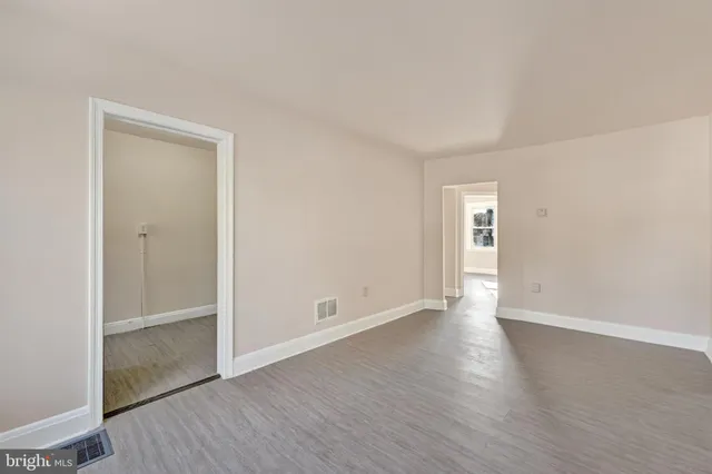 an empty room with wooden floor & closet area
