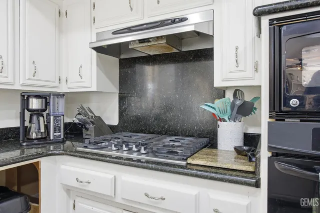 a kitchen with white cabinets and appliances