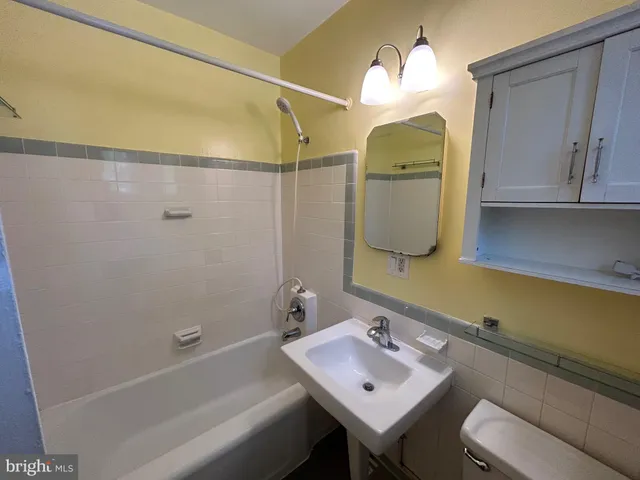 a bathroom with a sink mirror and a bathtub