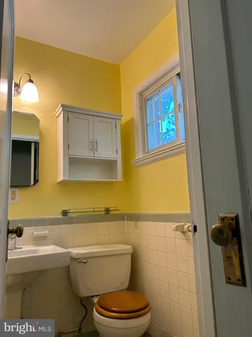 a bathroom with a toilet a sink and mirror