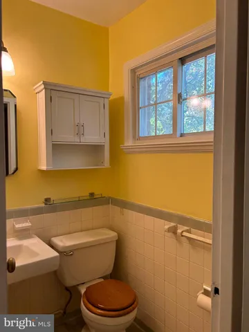 a bathroom with a toilet a sink and a mirror