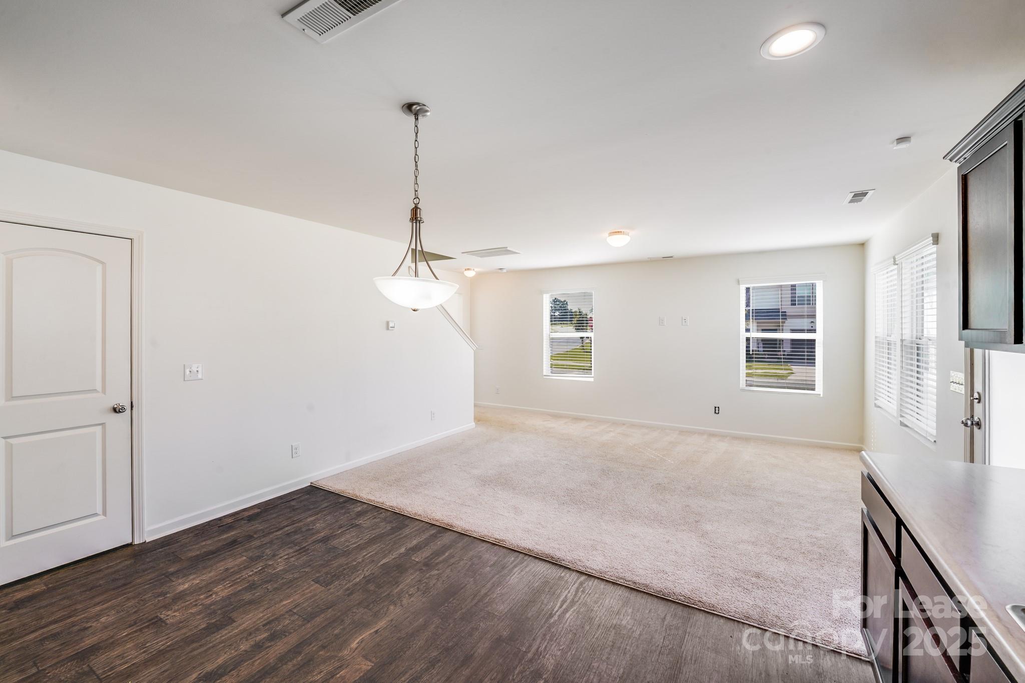 12915 Hill Pine Road Midland, NC 28107 - Photo 10 of 31 a view of an empty room with wooden floor and a ceiling fan