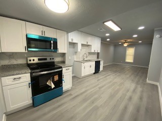 810 Clinton Park Street Houston, TX 77029 - Photo 14 of 14 a kitchen with stainless steel appliances kitchen island granite countertop a stove top oven a sink dishwasher a refrigerator and white cabinets with wooden floor