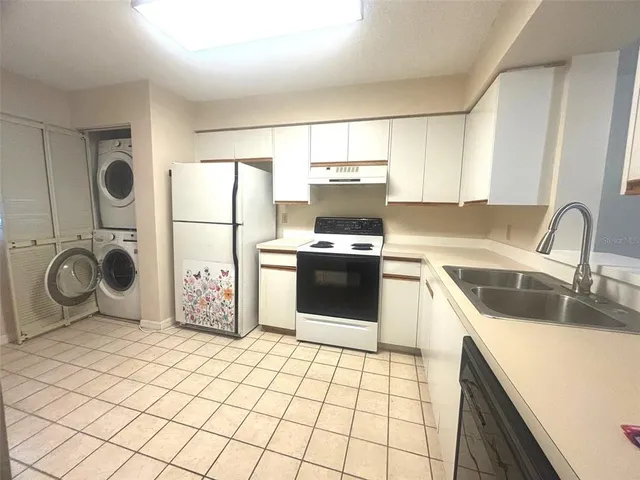 a kitchen with a sink a stove top oven and refrigerator