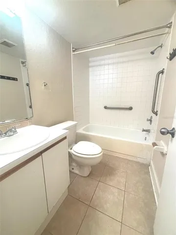 a bathroom with a granite countertop sink toilet a mirror and shower