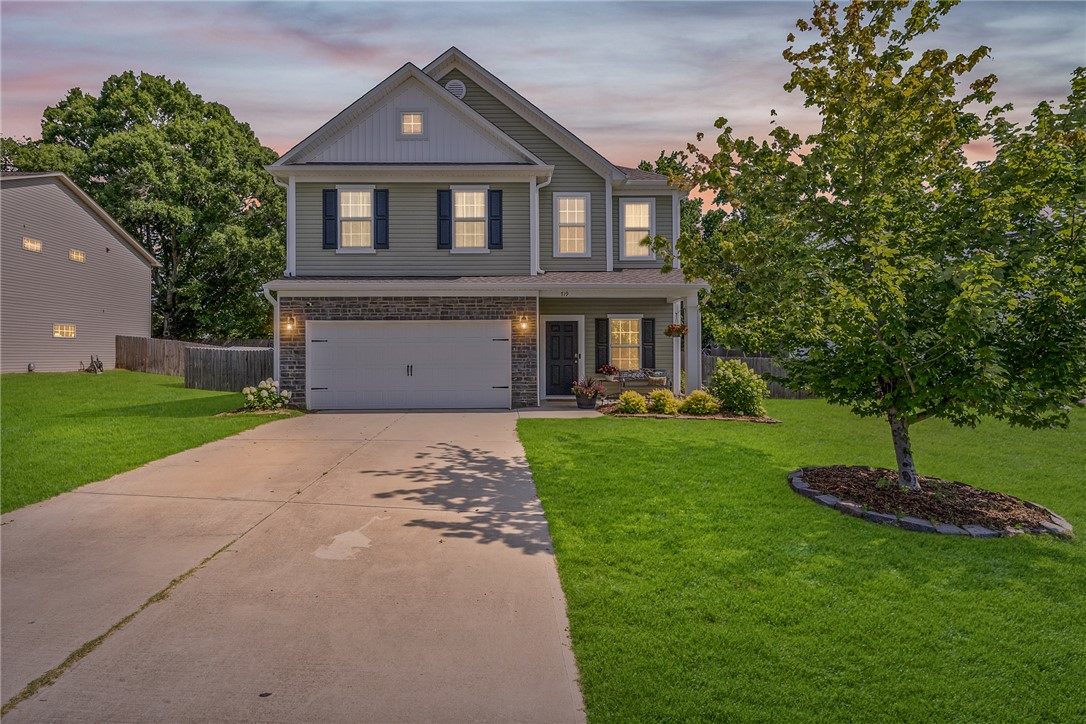 719 Camberwell Road Simpsonville, SC 29680 - Photo 42 of 47 A concrete driveway leads toward this classic two-story residence featuring siding and stone details.
