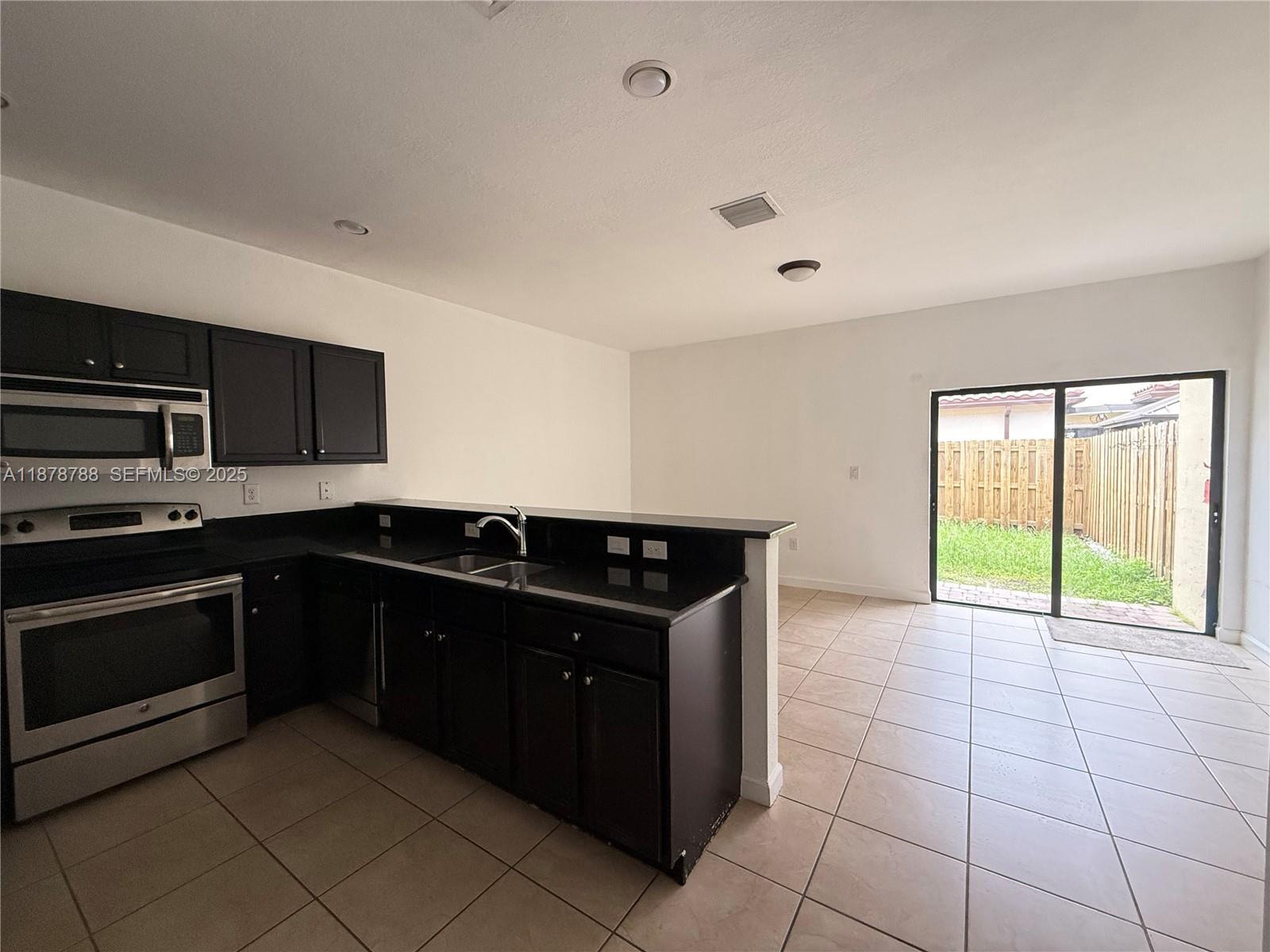 3204 Southeast 5th Court Homestead, FL 33033 - Photo 21 of 25 a kitchen with a cabinets and steel stainless steel appliances