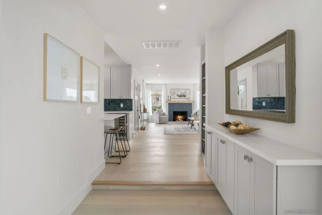 a view of a hallway with wooden floor and a living room