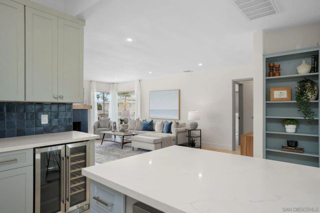 a large white kitchen with a stove a sink a refrigerator and cabinets