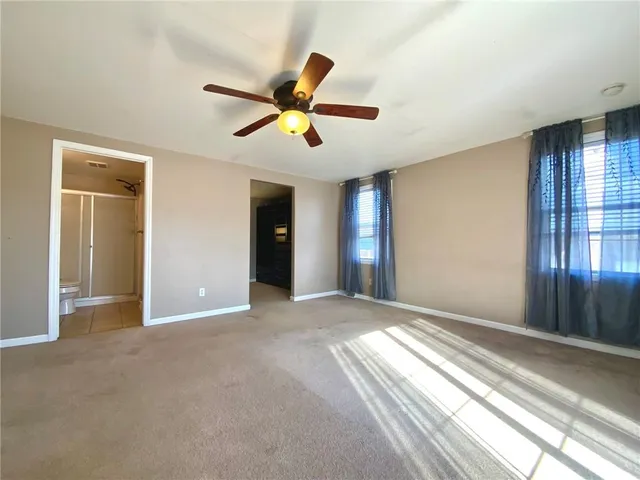 a view of empty room with window and ceiling fan