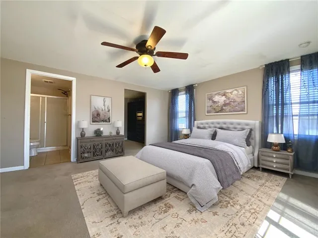 a spacious bedroom with a large bed and a chandelier