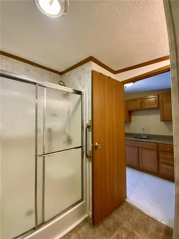a bathroom with a glass shower door and a sink