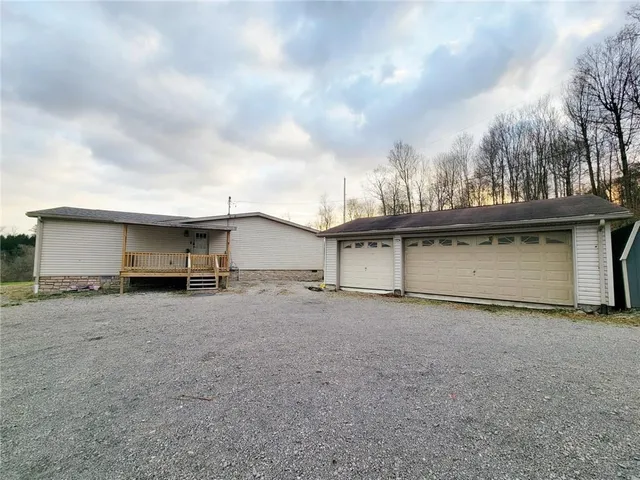 a view of a house with garage and trees