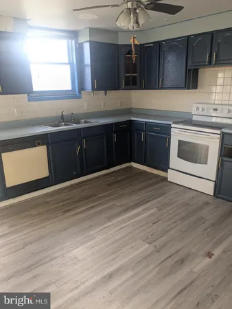 a kitchen with stainless steel appliances granite countertop a sink cabinets and wooden floor