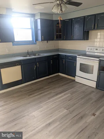 a kitchen with stainless steel appliances granite countertop a sink cabinets and wooden floor