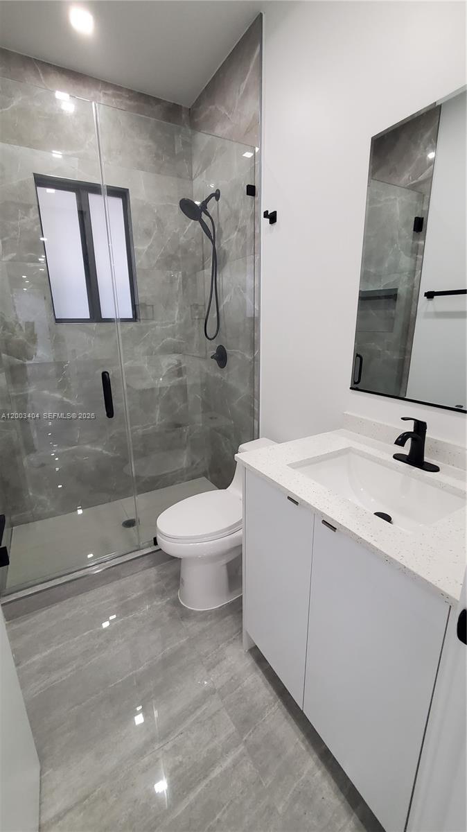 40 Southwest 34th Avenue, Unit C Miami, FL 33135 - Photo 16 of 24 a bathroom with a toilet sink and mirror