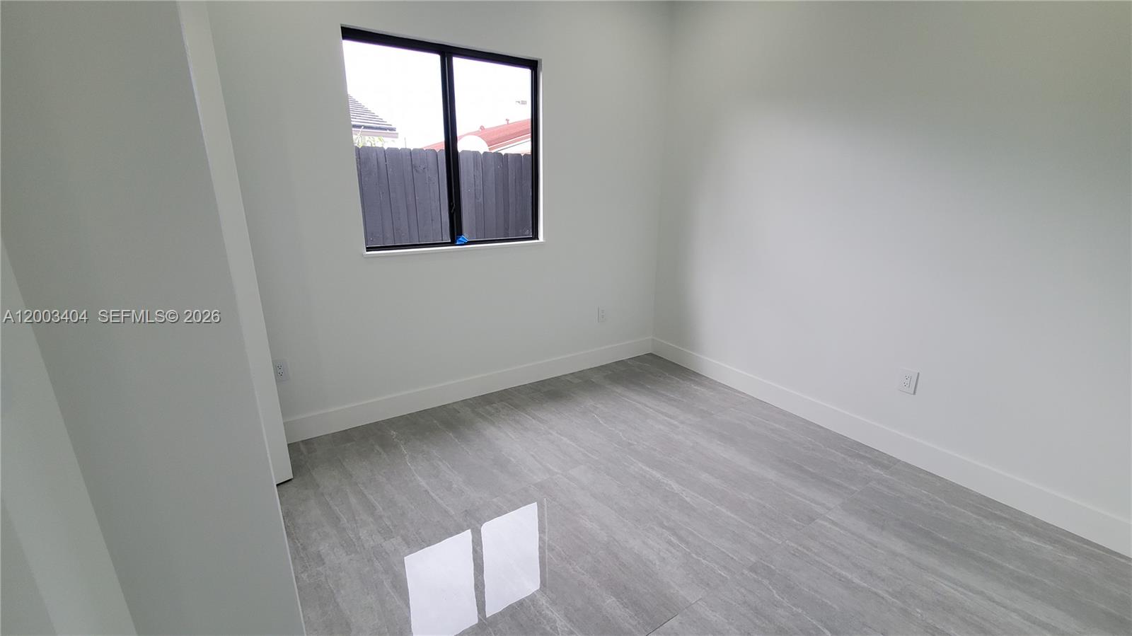 40 Southwest 34th Avenue, Unit C Miami, FL 33135 - Photo 19 of 24 an empty room with wooden floor and windows