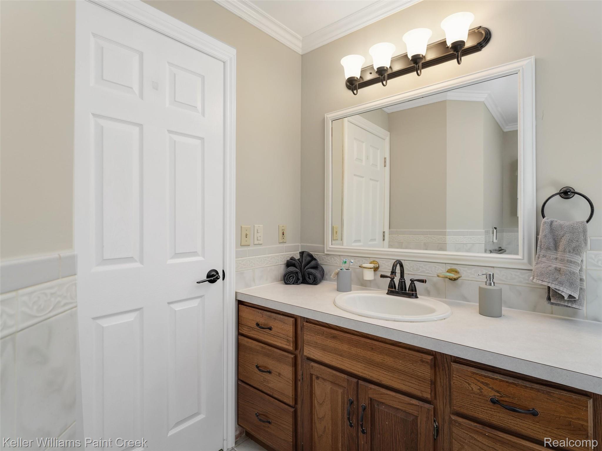 5813 36 Mile Road Romeo, MI 48065 - Photo 31 of 81 Vanity featuring a white countertop, an integrated sink, and an oil-rubbed bronze faucet