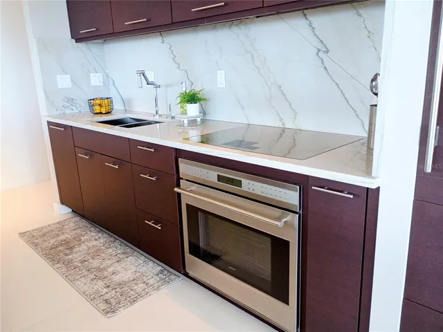 a kitchen with stainless steel appliances a stove a microwave a sink and cabinets