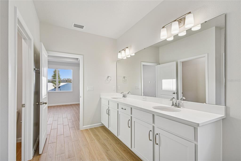 813 River Stone Trail Sanford, FL 32771 - Photo 14 of 33 a spacious bathroom with a double vanity sink and mirror