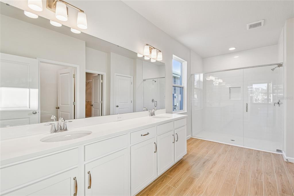 813 River Stone Trail Sanford, FL 32771 - Photo 17 of 33 a bathroom with a double vanity sink a mirror and a shower