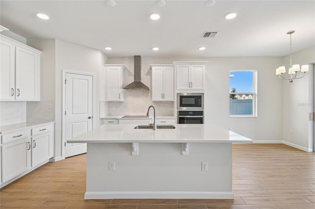 813 River Stone Trail Sanford, FL 32771 - Photo 6 of 33 a large kitchen with kitchen island a sink stainless steel appliances and cabinets