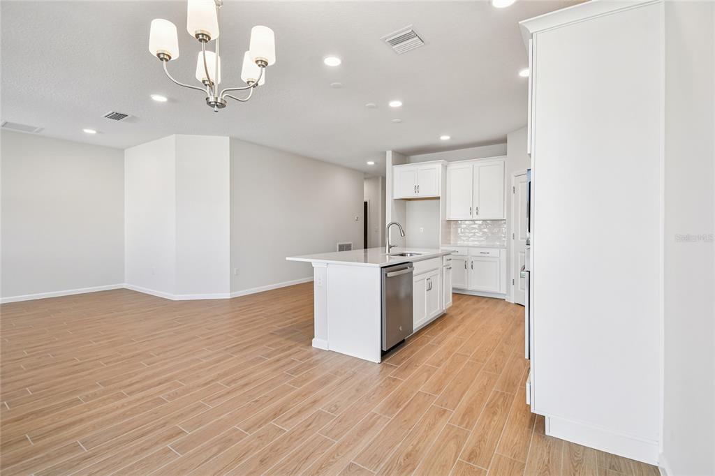 813 River Stone Trail Sanford, FL 32771 - Photo 8 of 33 a view of a kitchen with a sink and dishwasher a refrigerator with wooden floor