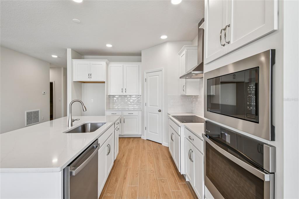 813 River Stone Trail Sanford, FL 32771 - Photo 10 of 33 a kitchen with stainless steel appliances granite countertop a sink and stove top oven