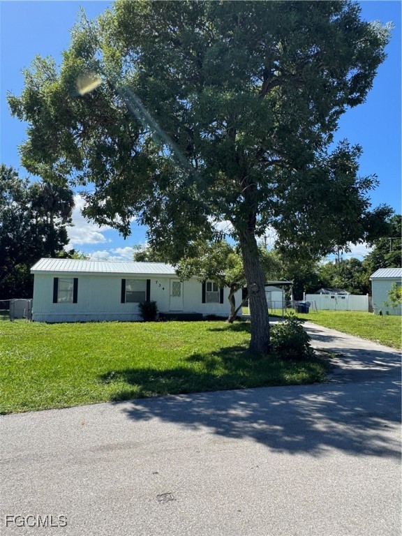 a front view of a house with a yard and trees